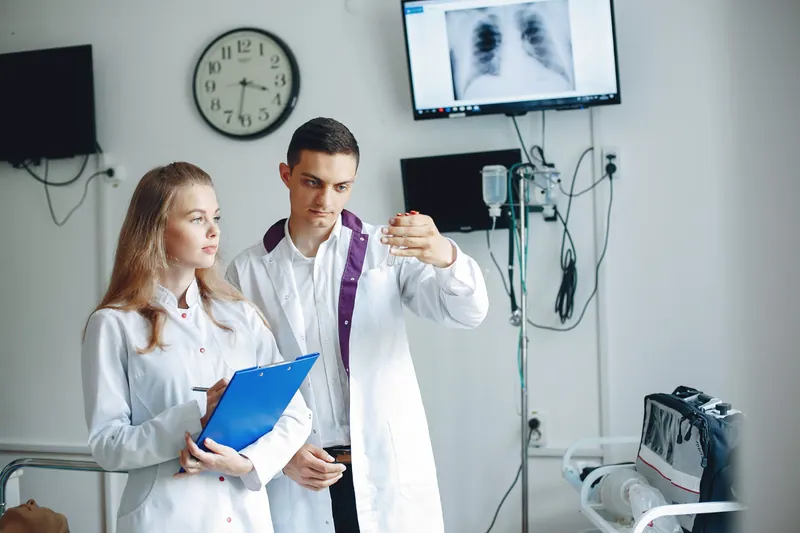 Medical professionals discussing an anatomical heart model in an examination room